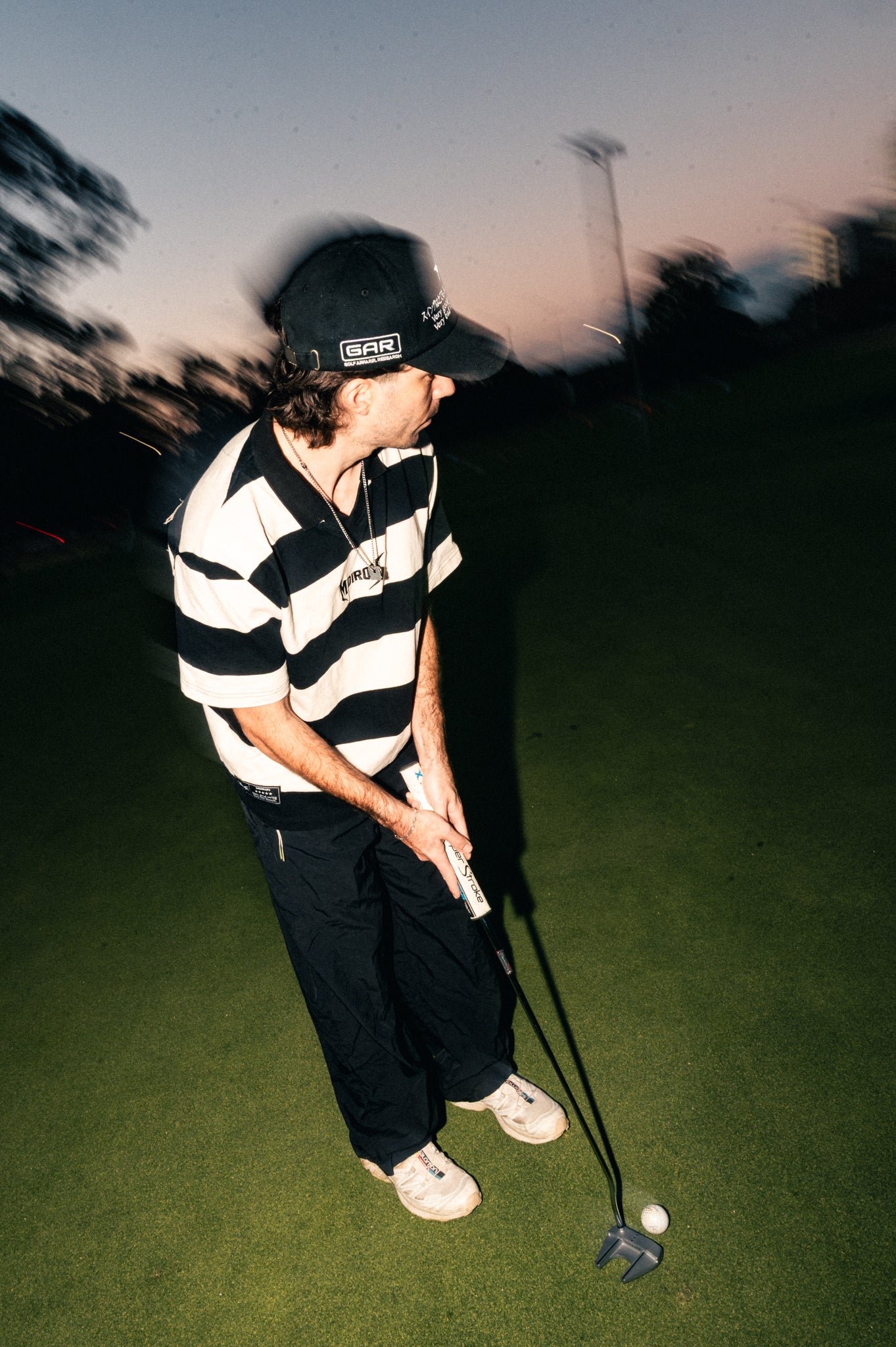 Person playing golf on a lush golf course with a blurred background flash photography